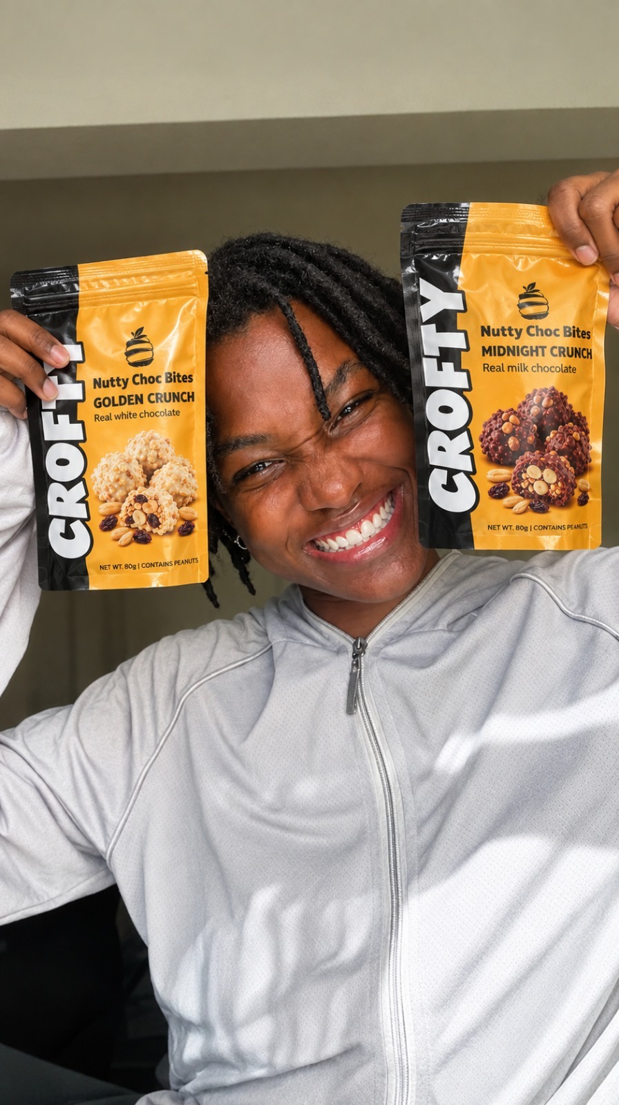 Smiling Crofty customer holding two Nutty Choc Bites packs